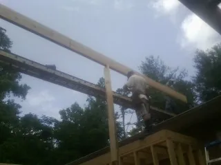 Carpenter setting a ridge beam over a new addition frame — Ice Dam Removal by Roofing Brothers in Piney Woods