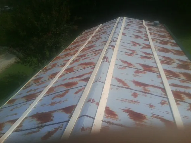 Rusted metal roof panels with new wood purlins before replacement — Storm Damage Roof Repair in Piney Woods by Roofing Brothers